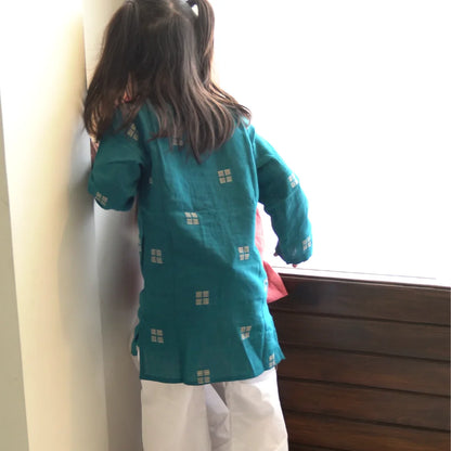 Back view of a girl in a teal full sleeve kurta with side slits and a white pajama