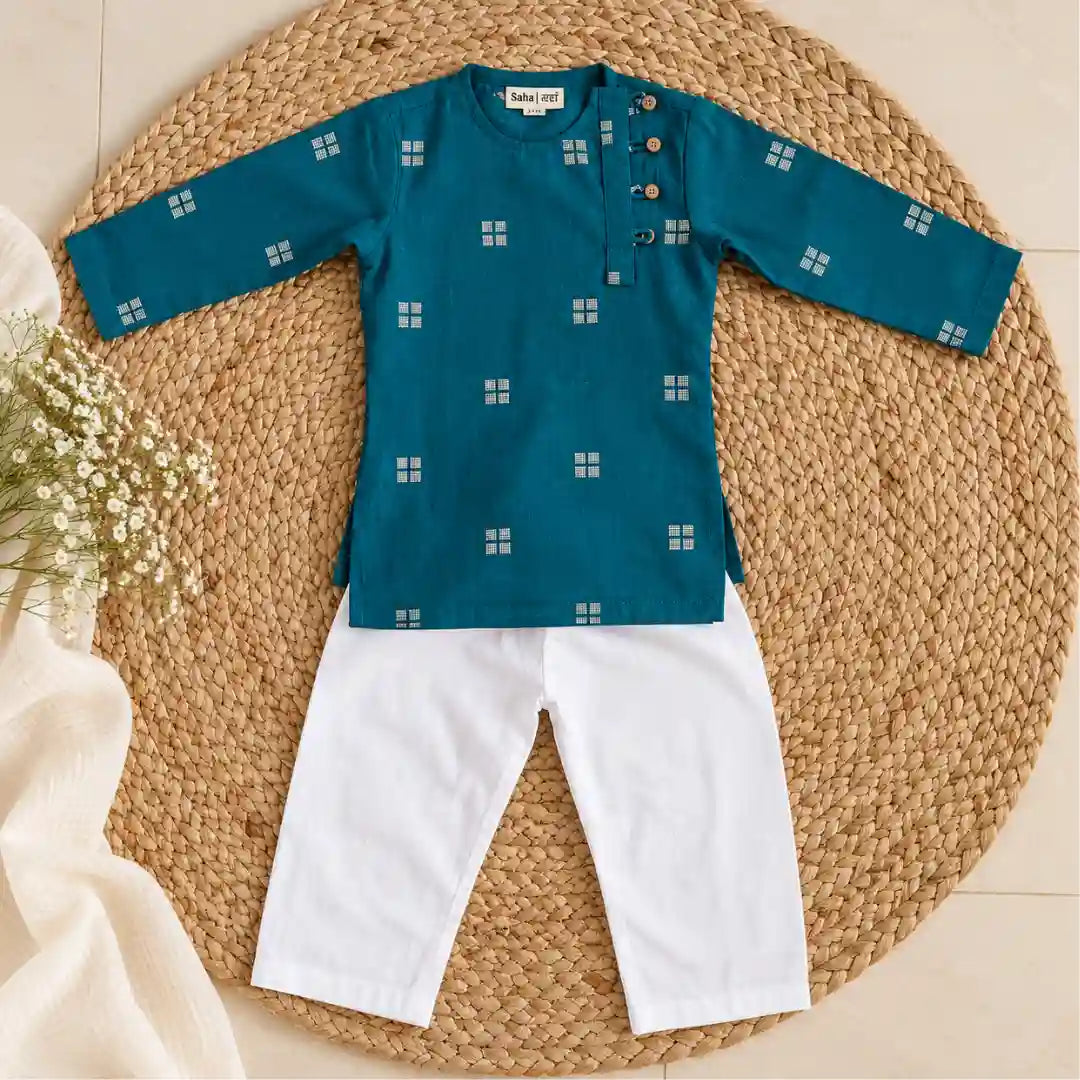 Flat lay of a teal full sleeve kurta with white woven square motifs and wooden buttons beside a white pajama