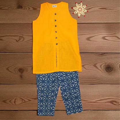 A two-piece children's outfit laid flat on a wooden surface, featuring a sleeveless bright yellow top with a button front and blue patterned pants with a white geometric design