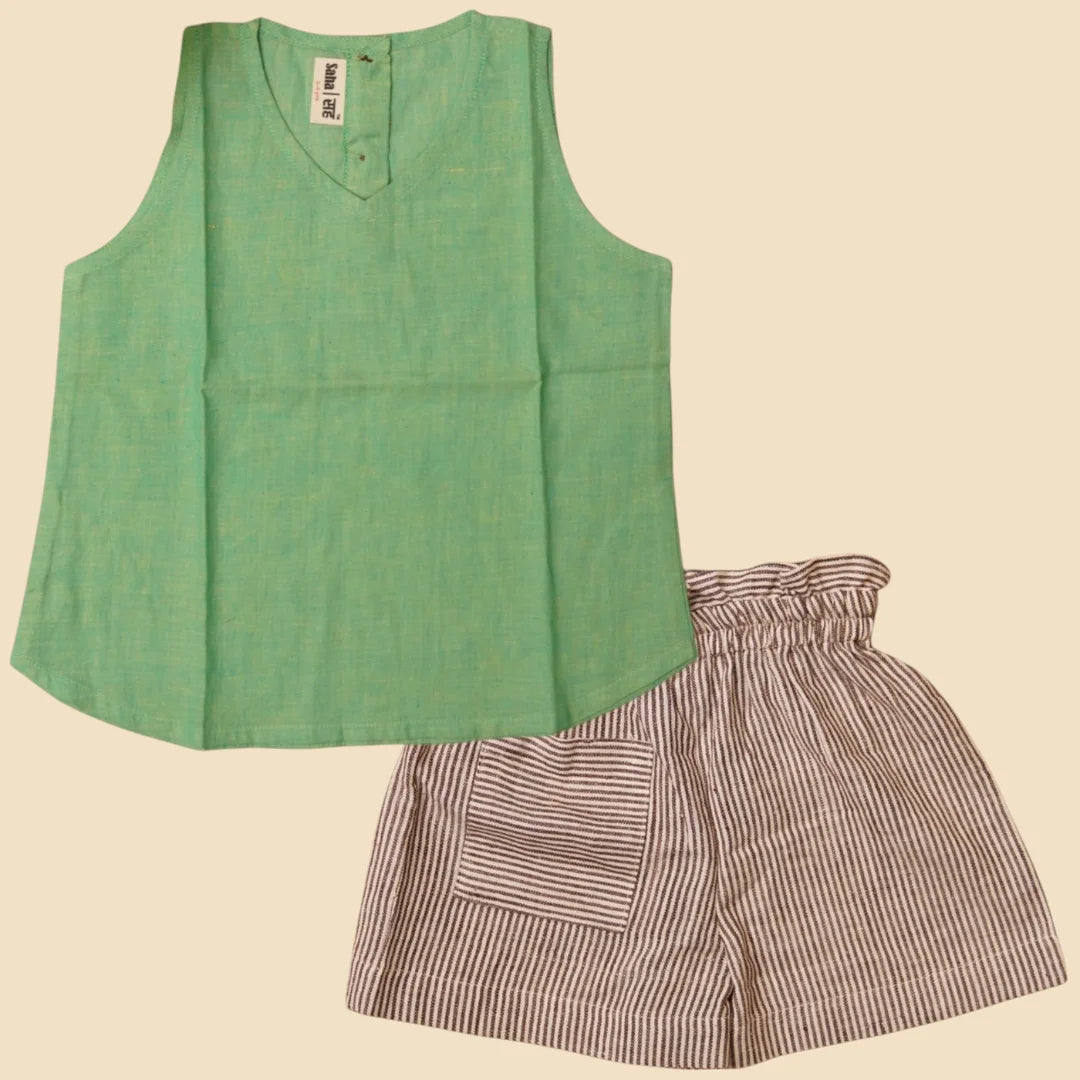 Green sleeveless top and striped shorts on a beige background